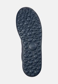 Suola di scarpa in gomma nera con texture circolare, caratterizzata da una varietà di rilievi per una presa migliore. Contrassegnata con "camper" e taglia "42".