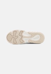 Suola della scarpa in bianco e beige con una superficie testurizzata, caratterizzata da un design a più motivi per aderenza e supporto.