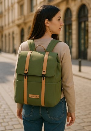 Sac à dos en toile verte avec des accents en cuir tan, rabat structuré, poches avant, bretelles ajustables et une poignée de transport supérieure.