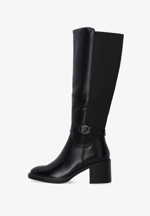 Black knee-high boots made of leather and fabric, featuring a rounded toe, a block heel, and a decorative strap with a circular metal accent.