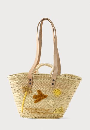 Sac cabas en paille tressée avec des bretelles en cuir fauve, de petites poignées et des motifs brodés de palmier, oiseau, soleil, nuage et colline sablonneuse sur le devant.