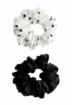 Two fabric scrunchies, one white with black polka dots and one solid black, displayed on a white background.