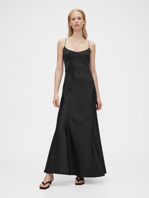 Abito maxi in satin nero con spalline sottili, corpino aderente e orlo svasato, che mette in evidenza una texture liscia e un design minimalista.