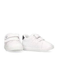 Zapatos de cuero blancos con correas de velcro, puntera redondeada, suela texturizada y acentos perforados en los laterales. Diseño compacto para facilitar su uso.