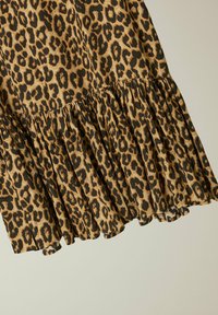 Vestido de estampado de leopardo con un dobladillo rizado, que presenta una combinación de colores marrón y negro, hecho de una tela ligera con una textura suave.