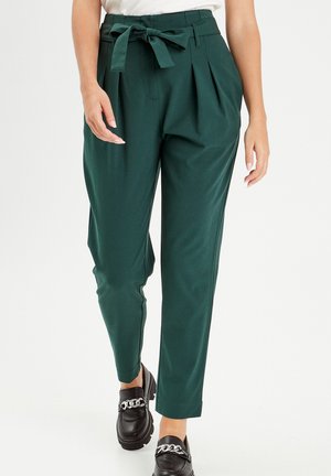 Green high-waisted trousers with pleats and a tied belt detail. Smooth fabric, tapered fit, featuring side pockets and ankle-length design.