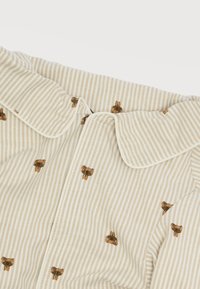 Ριγωτό ύφασμα σε κρέμ και μπεζ με γιακά Πίτερ Παν, διακοσμημένο με μικρά καφέ σχέδια αρκουδάκια.