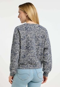 Felpa blu navy con un motivo floreale in beige chiaro. Presenta maniche lunghe e un col ribbed. Tessuto morbido con una vestibilità comoda.