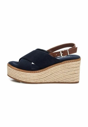 Sandali wedge blu navy con cinturini incrociati, dettaglio in corda di juta sulla suola e cinturino alla caviglia regolabile marrone.