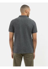 Kortsleeve, mørkegrå polo-shirt med en tekstureret stof, som har en traditionel krave og et subtilt tonet mønster.
