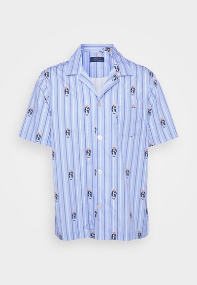 Camisa de botão de manga curta em azul claro com riscas verticais e pequenas figuras impressas. Apresenta um único bolso no peito e um tecido suave.