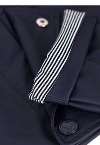 Tessuto blu navy con una texture liscia, caratterizzato da un colletto a strisce in bianco e blu navy. Include un dettaglio con bottone argento per la chiusura.