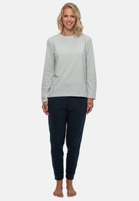 Grå långärmad bomullströja som kombineras med marinblå joggerbyxor, med elastiska muddarna och en avslappnad passform. Inga synliga mönster eller detaljer.