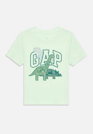 T-shirt vert clair pour enfants avec des motifs de dinosaures mécaniques verts et bleus et le grand texte "GAP" sur le devant.