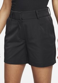 Pantalones cortos negros hechos de tela ligera con una textura suave. Cuentan con un frente plano, bolsillos laterales y un diseño simple en la cintura.