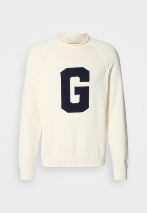 Cream sweater made of knit fabric featuring a navy blue 'G' logo design. It has a round neck and ribbed cuffs and hem.