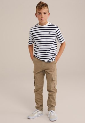 Stribet kortærmet T-shirt i hvid og marineblå med rund halsudskæring; parret med beige cargo bukser med sidelommer. Hvide sneakers.