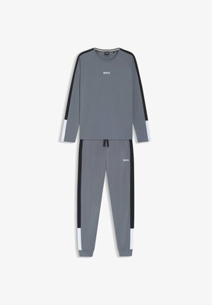 Conjunto de ropa deportiva gris que incluye una camiseta de manga larga con detalles en negro y azul claro, y pantalones a juego, ambos con un corte holgado y detalle de logo.