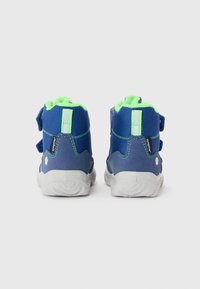 Høye sneakers i blått og grønt. Har en teksturert stoffoverdel med borrelåsremmer, polstret krage og gummisåle.