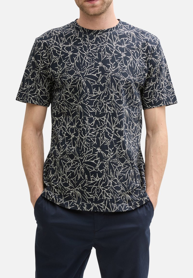 T-shirt à manches courtes bleu marine en tissu léger avec un motif floral blanc, col rond et coupe décontractée.