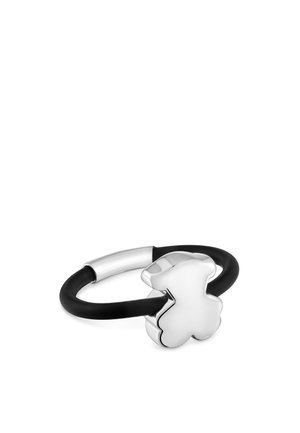 Colgante de osito de peluche de plata unido a un anillo de goma negro con un cierre de plata, aislado sobre fondo blanco.