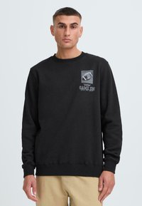 Black sweatshirt with a crew neck, long sleeves, and ribbed cuffs. Features a graphic print on the chest that includes the text "GAME ON."