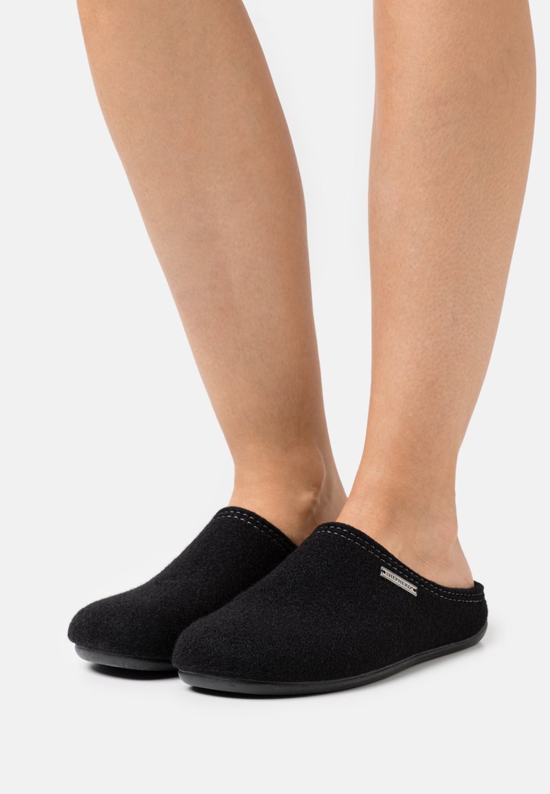 Black felt slip-on slippers feature a rounded toe, textured upper, and rubber sole with subtle stitching and a small logo accent.