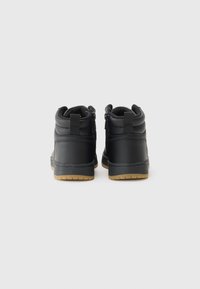 Zwarte mid-top sneakers van glad synthetisch materiaal, met een gewatteerde kraag en rubberen zool met een gestructureerde gumzool. Zijritsen voor het sluiten.