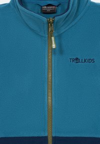 Γαλάζια φλις ζακέτα με ψηλό γιακά, μπροστινό φερμουάρ και σκούρο μπλε κάτω μέρος. Διαθέτει το λογότυπο "TROLLKIDS" σε ναυτικό χρώμα.