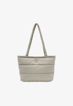 Sac tote rembourré en beige clair, avec un design matelassé, deux poignées douces et un petit logo en accent sur le devant.
