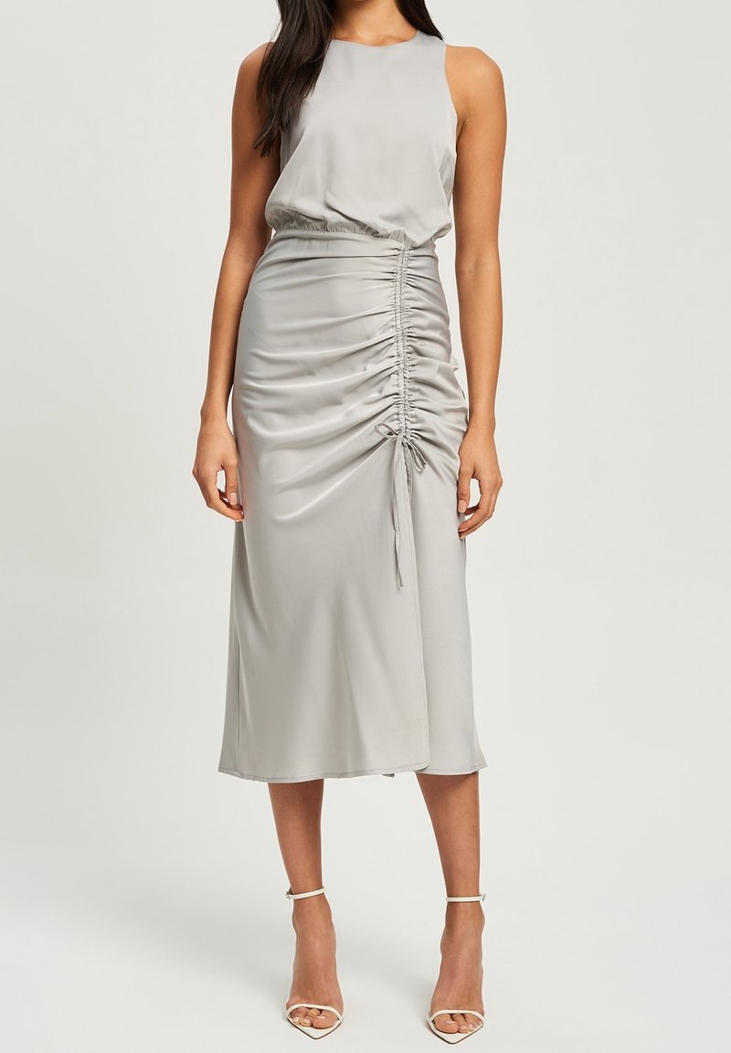 Ärmlös grå midiklänning i mjukt material, med rynkdetaljer längs kjolen och dragskoakenter vid midjan.