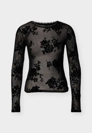 Haut noir à manches longues en tissu transparent avec motifs en velours floral. Présente un col rond et une bordure en dentelle au niveau du col et de l'ourlet.