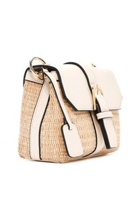 Een rieten handtas met een crèmekleurige leren flap en zwarte accenten, voorzien van een gouden sluiting en een afneembare tag. Compact en gestructureerd ontwerp.
