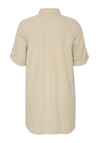 Chemise beige avec des manches courtes retroussées, design col, détail de plis au dos et tissu texturé. Convient pour un usage décontracté.