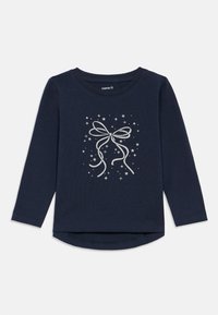 T-shirt a maniche lunghe blu navy in tessuto morbido, con una grafica di un fiocco bianco circondato da scintille. Orlo arrotondato e collo a giro.