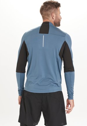 Langärmliges Sportoberteil in Blau mit schwarzen Akzenten; verfügt über eine glatte Textur, taillierte Passform und reflektierende Linien auf der Rückseite.
