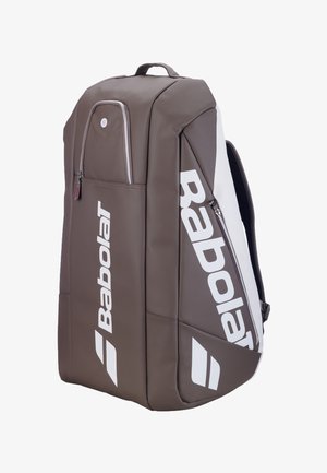 Brun og hvid Babolat sportstaske med flere lynlåslommer og polstrede skulderstropper til tennistilbehør.