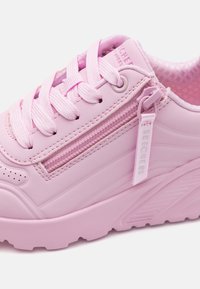Scarpa sintetica rosa con design lace-up, dettaglio con zip e accenti testurizzati. Suola chunky e fori per traspirabilità.