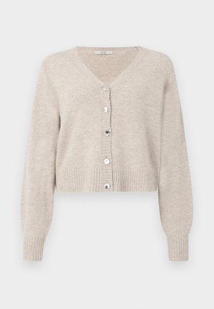 Béžový zkrácený kardigán s V-výstrihom, dlhými rukávmi, rebrovanými manžetami a piatimi lesklými gombíkmi vpredu. Mäkká textúra s minimálnym dizajnom.