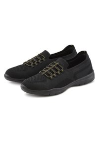 Scarpe da ginnastica nere realizzate in rete e materiale sintetico, dotate di lacci elasticizzati con accenti dorati e una suola in gomma flessibile.
