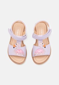 Liila sandalit ühe rihmaga, särava roosa flamingo disainiga ja beežiga tallaga. Lihtsaks kandmiseks Velcro sulg.