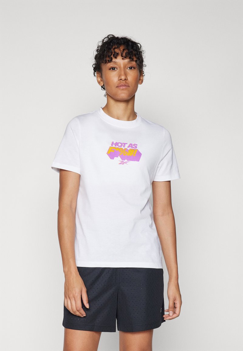 T-shirt di cotone bianco con una stampa grafica colorata in viola e giallo che recita "HOT AS F%*#!". Abbinato a pantaloni corti scuri e texture.