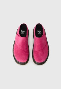 Pink suede slip-on shoes with a rounded toe, black rubber sole, yellow stitching, and a smooth texture across the upper.