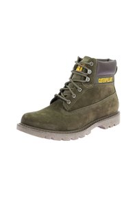Bottine en suede verte avec un bout renforcé, des accents gris et une semelle en caoutchouc blanc dotée d'une semelle sans glissement pour une meilleure traction.