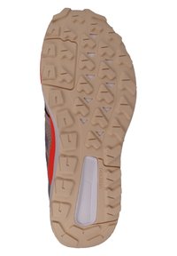 Trail running shoe outsole with a textured beige rubber surface, patterned for grip, featuring a central white section labeled "TRAXION."