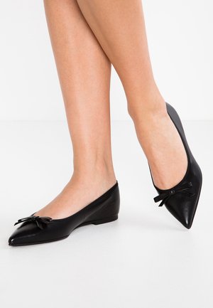 Ballerines en cuir noir avec un design à bout pointu et un petit nœud sur le devant. Texture lisse avec un petit talon.