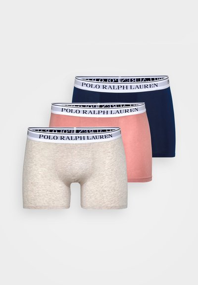 Três pares de boxers para homem em bege, rosa e azul-marinho, com uma cintura branca onde está impresso "POLO RALPH LAUREN" em preto.