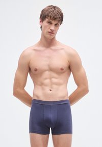 Calzoncillos tipo bóxer de algodón azul marino con una cinturilla suave y una costura frontal para mejor ajuste, que muestran una textura suave y un diseño ajustado.