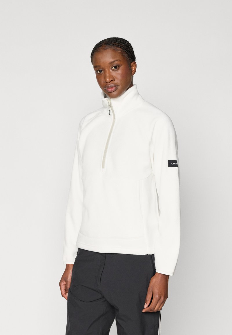 Λευκό φλις πουλόβερ με ψηλό γιακά, μισό φερμουάρ μπροστά και λεπτομέρεια λογότυπου στο αριστερό μανίκι. Λείος υφασμάτινος χαρακτήρας, άνετη εφαρμογή.