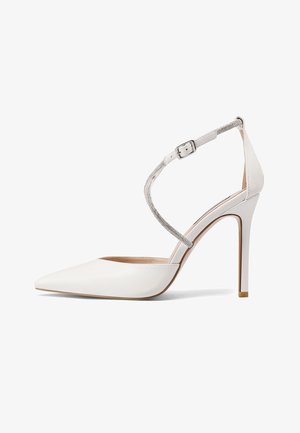 Pump alto in vernice bianca con punta affusolata e sottile cinturino alla caviglia, caratterizzato da un abbellimento scintillante e un tacco a stiletto sottile.